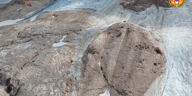 This image released on Sunday, July 3, 2022, by the Italian National Alpine and Cave Rescue Corps shows the glacier in Italy's Alps near Trento a large chunk of which has broken loose, killing at least six hikers and injuring eight others. Alpine rescue service officials, which provided that toll Sunday evening, said it could take hours to determine if any hikers might be missing. The National Alpine and Cave Rescue Corps tweeted that the search of the involved area of Marmolada peak involved at least five helicopters and rescue dogs. 