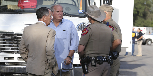 Uvalde Mayor Don McLaughlin, second from left, speaks with Texas Department of Public Safety troopers outside Robb Elementary School in Uvalde, Texas, on Wednesday, May 25.