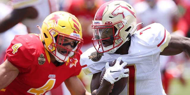 Victor Bolden Jr. #7 of Birmingham Stallions runs the ball as LaDarius Wiley #4 of Philadelphia Stars defends in the third quarter of the game at Protective Stadium on May 15, 2022 in Birmingham, Alabama.