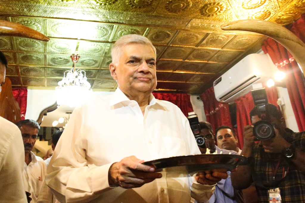 Ranil Wickramasinghe arrive at a Buddhist temple and receives blessings from a Buddhist monk as he offers prayers.