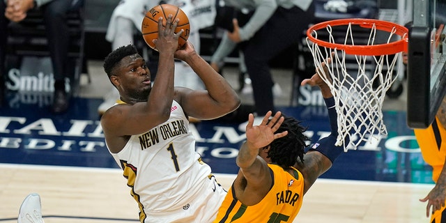 New Orleans Pelicans forward Zion Williamson (1) shoots as Utah Jazz center Derrick Favors (15) defends during the first half of an NBA basketball game Tuesday, Jan. 19, 2021, in Salt Lake City. (AP Photo/Rick Bowmer)