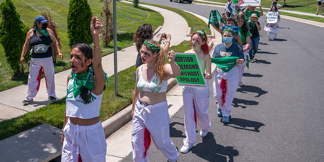 Abortion-rights activists with Rise Up 4 Abortion Rights chant after marching to the home of Supreme Court Justice Amy Coney Barrett on June 18, 2022 in Falls Church, Virginia. (Photo by Nathan Howard/Getty Images)