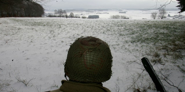 A man dressed as a U.S. soldier looks at the site of the Battle of the Bulge before a ceremony at the Mardasson World War II memorial monument in Bastogne, Dec. 18, 2004. 