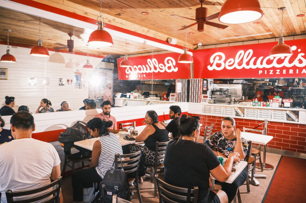A busy restaurant floor at Bellucci's Pizza in Astoria, Queens.