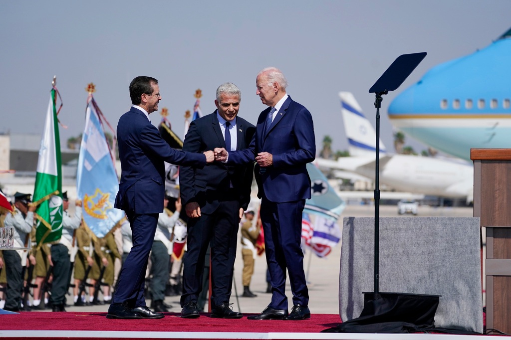 President Joe Biden greets President Isaac Herzog, left, after arriving at Ben Gurion Airport, Wednesday, July 13, 2022, in Tel Aviv, as Israeli Prime Minister Yair Lapid, center, looks on