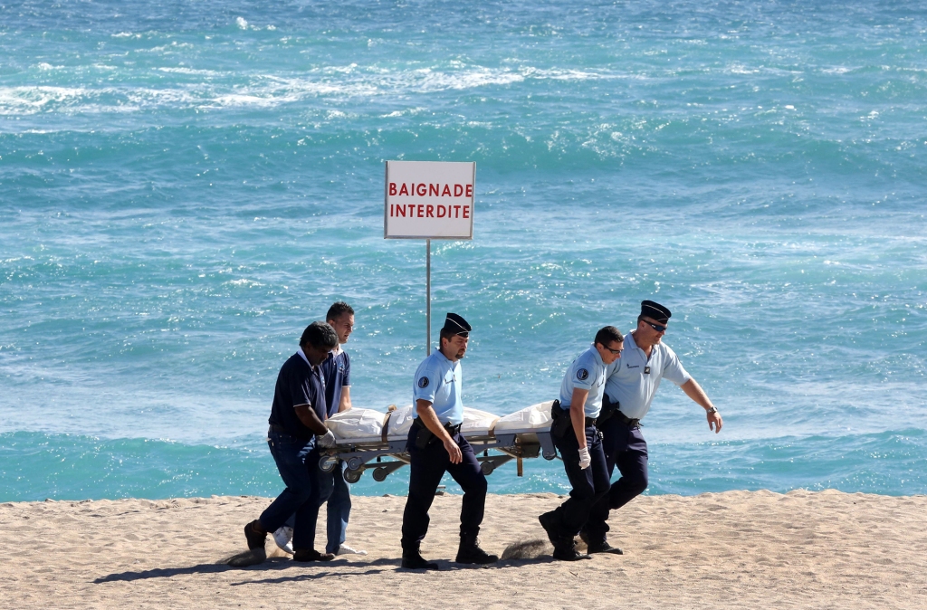 French gendarmes carry the corpse of a French surfer attacked and killed by a shark on Reunion Island.