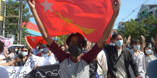 Anti-coup protesters display a party flag of the National League for Democracy (NLD) during a demonstration in Yangon, Burma, Friday, May 14, 2021. 