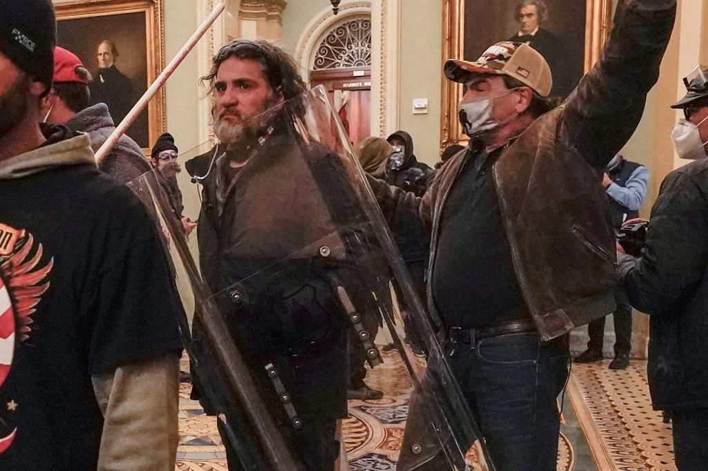 Rioters are confronted by U.S. Capitol Police officers outside the Senate Chamber.