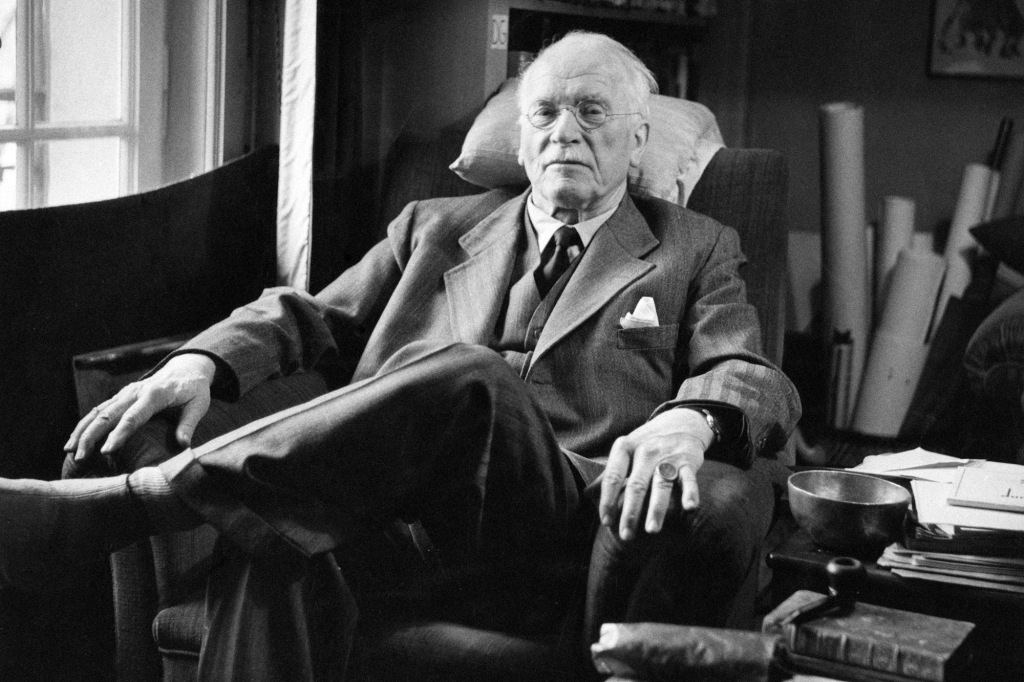 Carl Jung seated in a chair. 