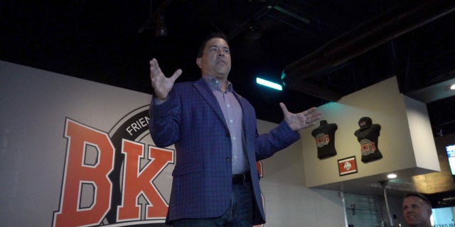 Kelly Cooper, a veteran running competing in the Republican primary for Arizona's 4th District, stands on a chair as he gives a short speech.