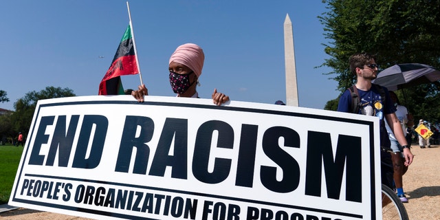 Demonstrators hold up banners during the march marking the 58th anniversary of Martin Luther King Jr.'s March on Washington, Aug. 28, 2021. (AP Photo/Jose Luis Magana)