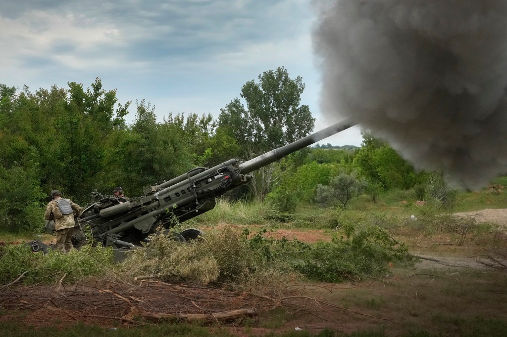 Ukrainian soldiers fire at Russian positions from a U.S.-supplied M777 howitzer.
