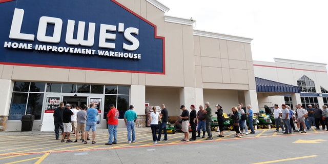 People line up to go into the Lowe's as they tried to gather supplies after rains and floods from Tropical Storm Harvey started to subside, Wednesday, Aug. 30, 2017, in Atascocita, Texas.