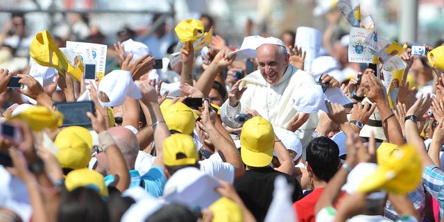 LAMPEDUSA, ITALY - JULY 08:  Pope Francis waves to the faithful as he arrives in the island on July 8, 2013 in Lampedusa, Italy. On his first official trip outside Rome, Pope Francis arrived at Lampedusa airport and then boarded a boat accompanied by fishermen in their own boats to lay a wreath in the sea in memory of those who lost their lives in the crossing. The Pope also met with a group of immigrants at the pier and celebrated mass.  (Photo by Tullio M. Puglia/Getty Images)