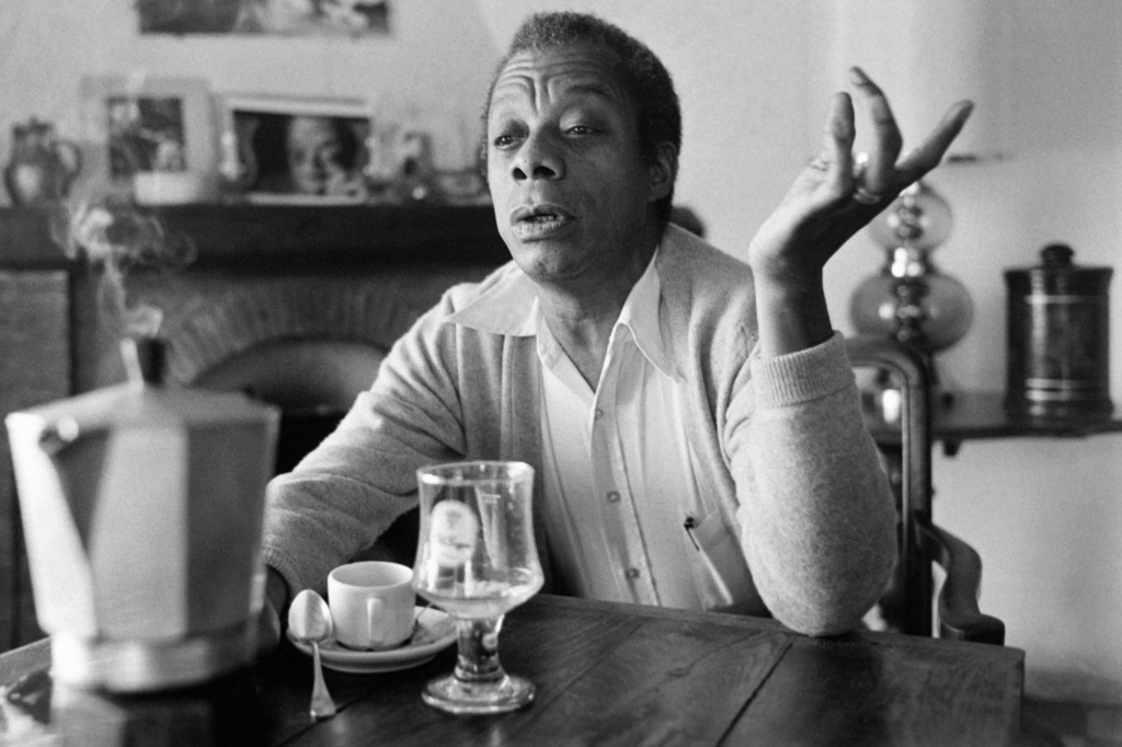 James Baldwin in a black and white portrait wearing a white shirt. 