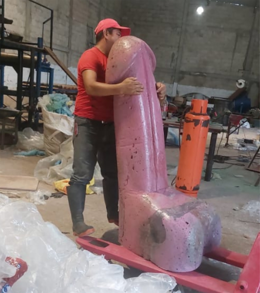 An engineer holding a penis statue