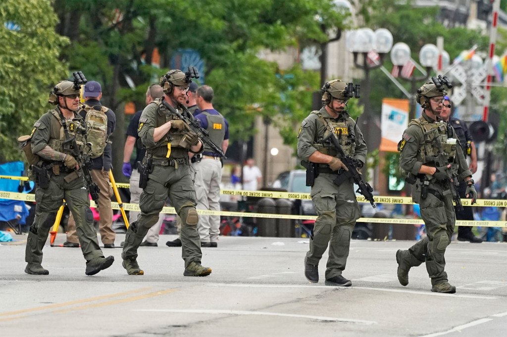 Law enforcement search after a mass shooting at the Highland Park Fourth of July parade in downtown Highland Park, Ill., a suburb of Chicago, on Monday, July 4, 2022. (AP Photo/Nam Y. Huh)