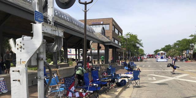 Empty chairs sit along the sidewalk after parade-goers fled Highland Park's Fourth of July parade after shots were fired, Monday, July 4, 2022 in Chicago. (Lynn Sweet/Chicago Sun-Times via AP)