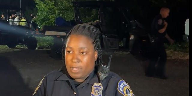 An Indianapolis police officer updates the media at the scene where four bodies were found in a pond Tuesday night. 