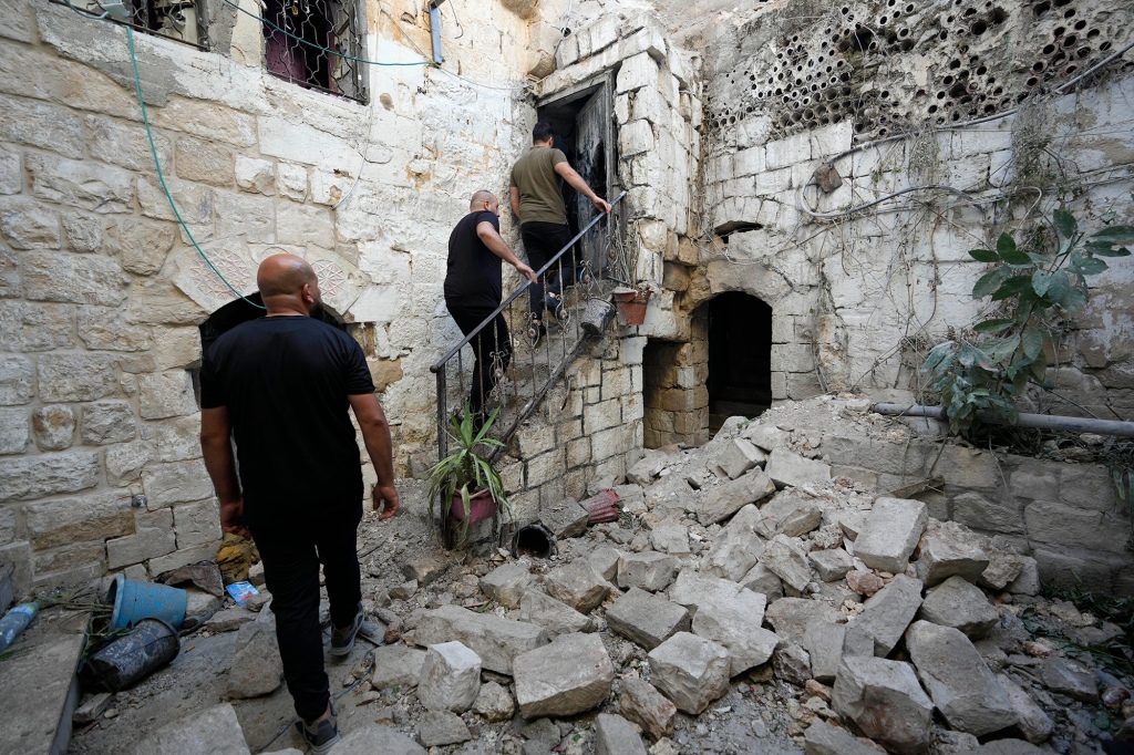 Palestinians inspect the damage to a house.