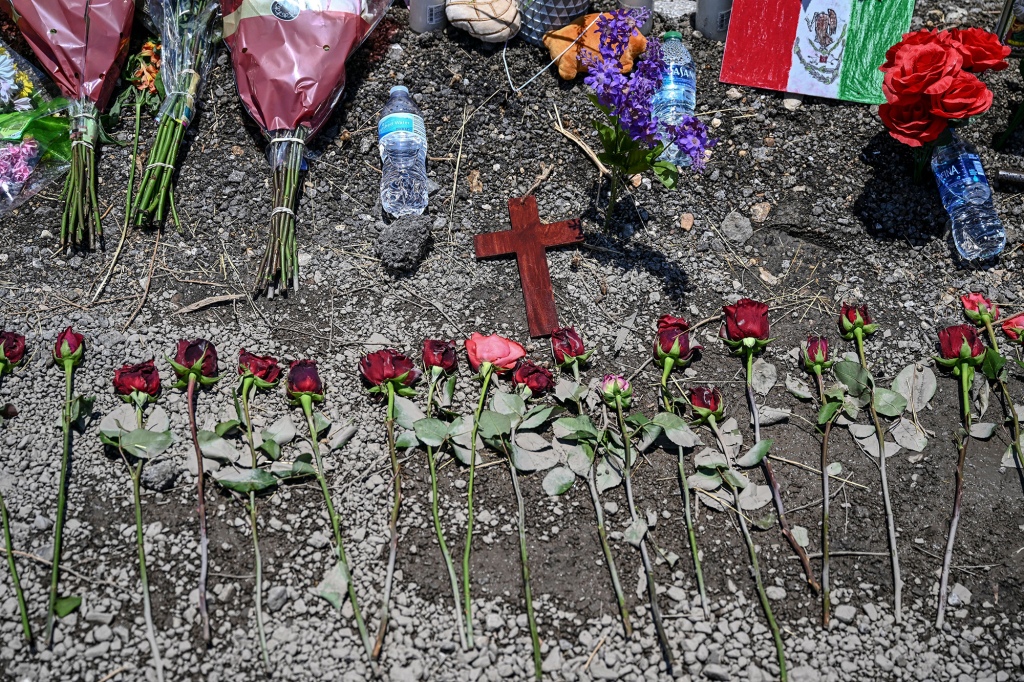 Flowers are displayed at a makeshift memorial at the spot where a tractor-trailer was discovered with migrants inside, outside San Antonio, Texas, on June 29, 2022.