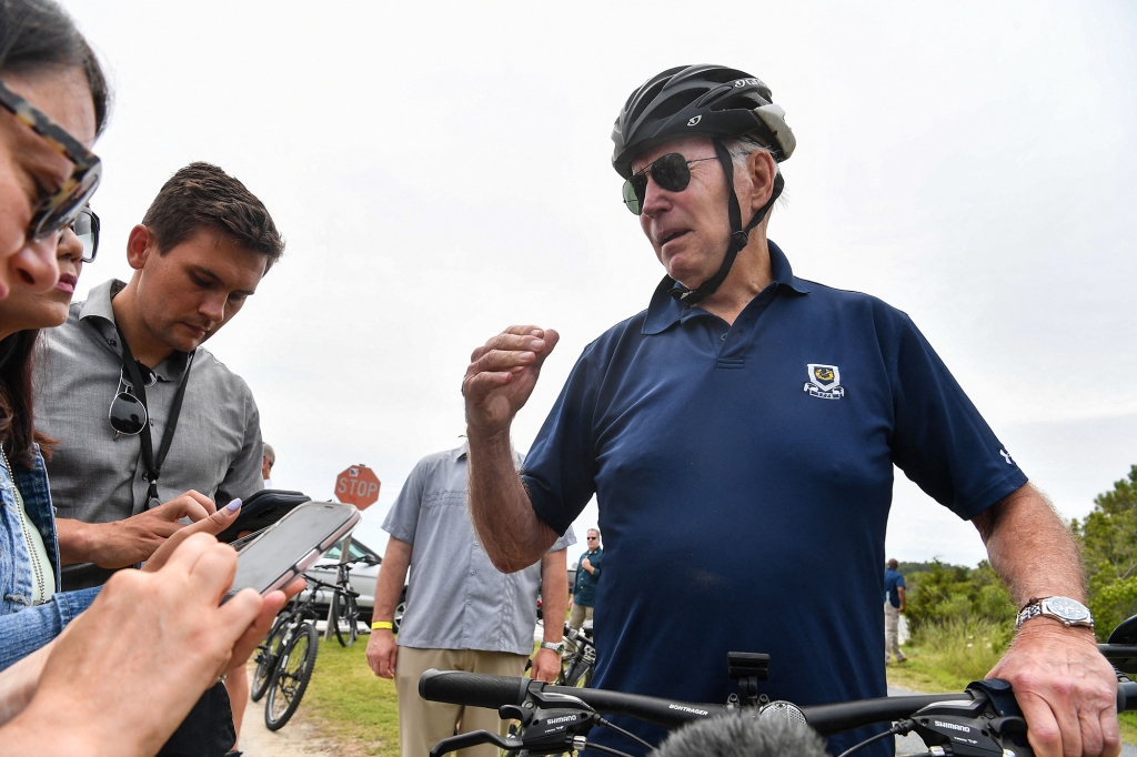 US President Joe Biden stops to talk to reporters during a bike ride in Gordon's Pond State Park in Rehobeth Beach, Delaware on July 10, 2022.