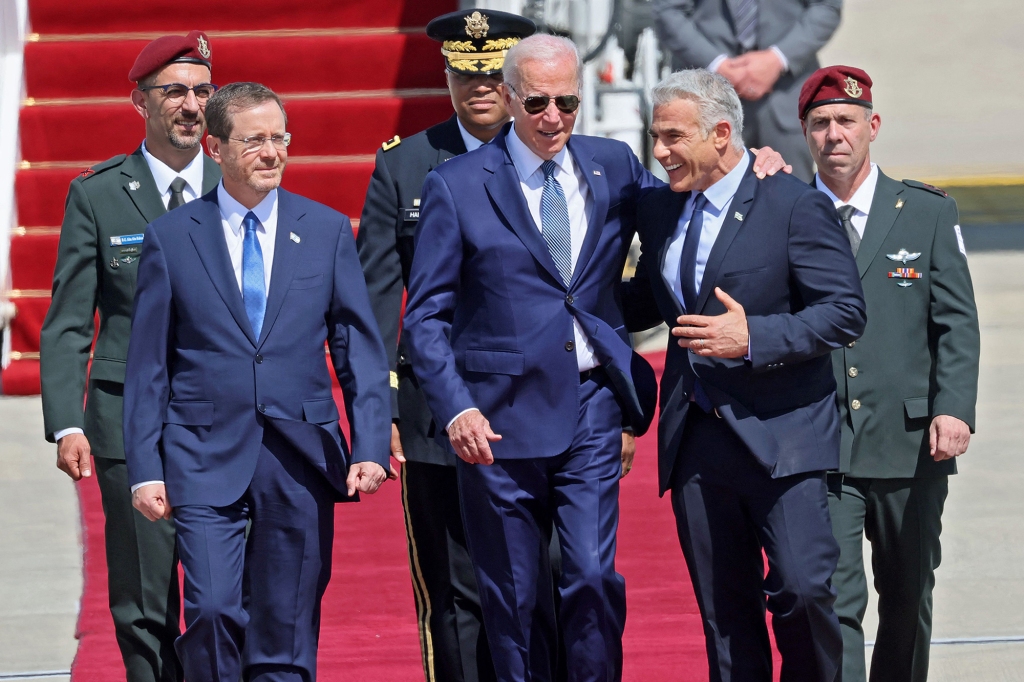 President Joe Biden touches Israeli Prime Minister Yair Lapid’s shoulders while walking with Israeli President Isaac Herzog (left).