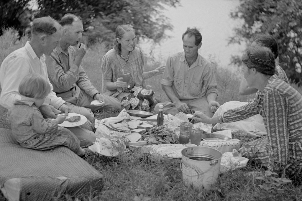 A family enjoys a July 4th fish fry during a picnic, circa 1940.