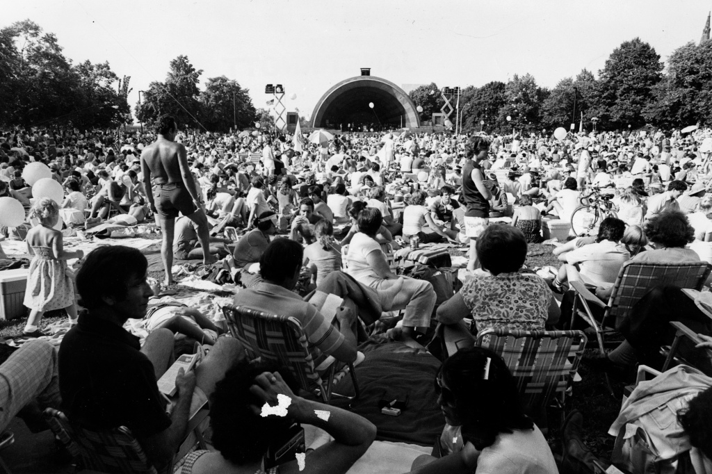 A massive crowd gathers to watch a 4th of July performance at the Hatch Memorial Shell in Boston, circa 1980. 