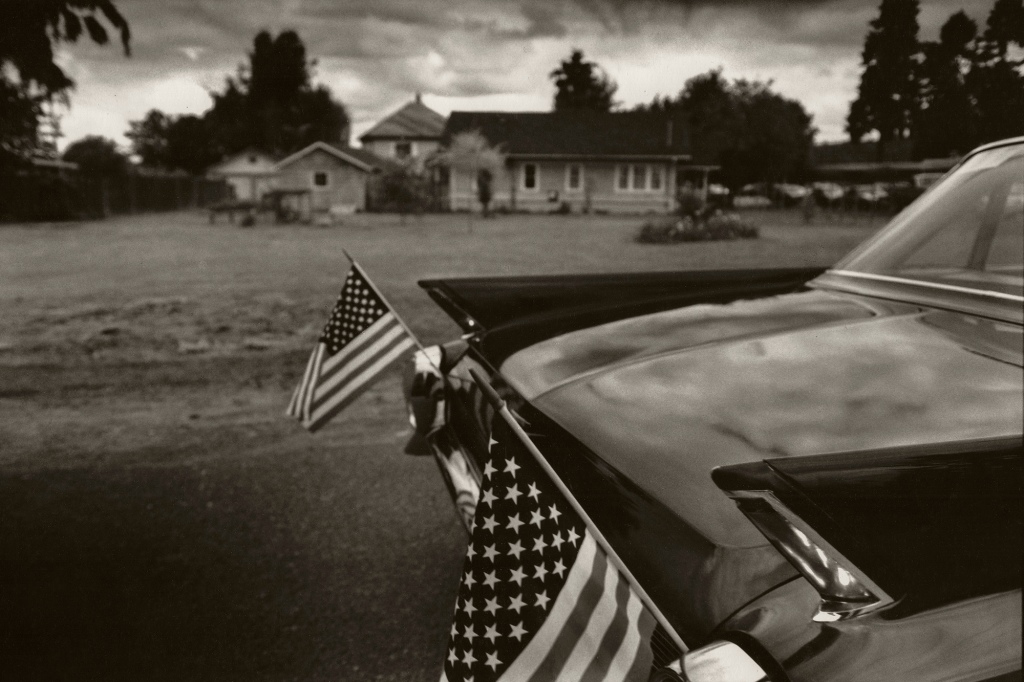 A car shows off two American flags before a July 4th parade in Carnation, Washington, circa 1990.