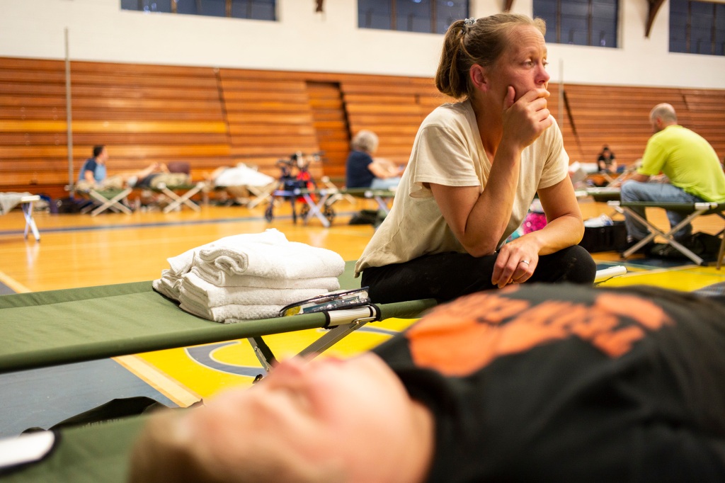 April Stivers, 38, of Lost Creek, Kentucky, takes a moment to herself in the Hazard Community & Technical College, where survivors of the major flooding in Eastern Kentucky were taken shelter Thursday in Breathitt County, Kentucky. 