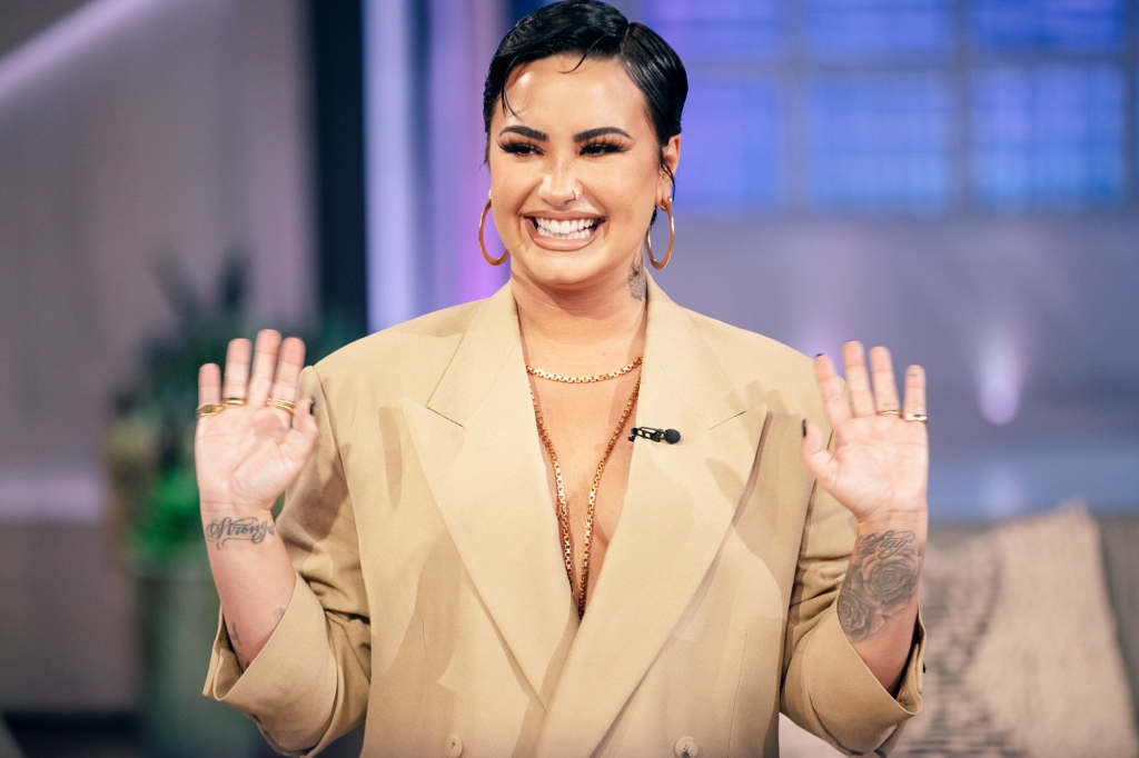 Demi Lovato poses in a tan blazer. 