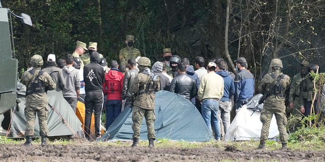 FILE - Polish security forces block migrants stuck on the border with Belarus in Usnarz Gorny, Poland, Sept. 1, 2021. A year after migrants started crossing into the European Union from Belarus to Poland, Polish authorities are planning to announce Thursday that a 5.5-meter-tall steel wall along its border to the north with Belarus is set to be completed. The purpose of the wall is to keep out asylum seekers fleeing conflict and poverty in the Middle East and Africa. 