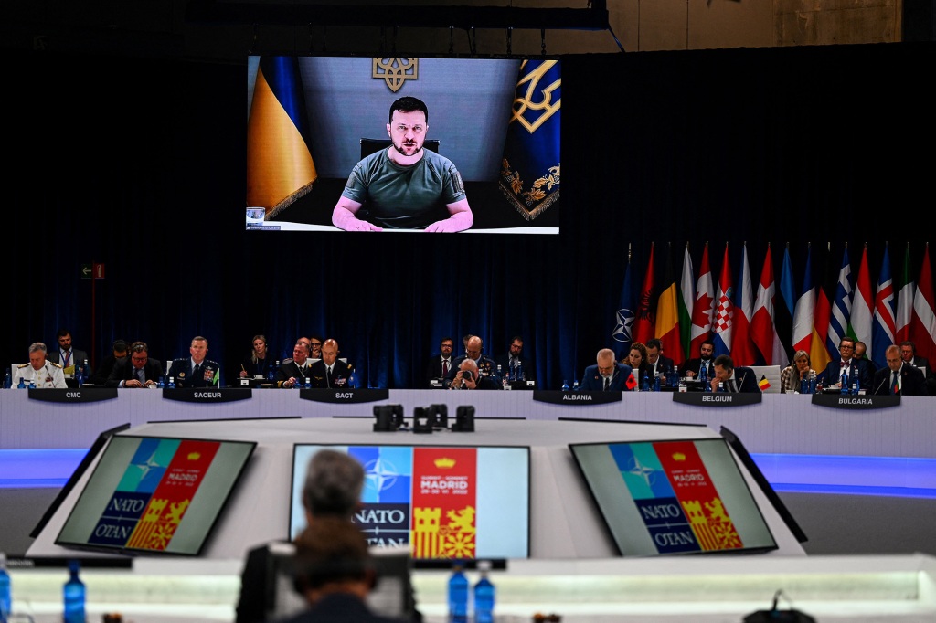 TOPSHOT - Ukraine's President Volodymyr Zelensky appears on a giant screen as he delivers a statement at the start of the first plenary session of the NATO summit at the Ifema congress centre in Madrid, on June 29, 2022. (Photo by GABRIEL BOUYS / AFP) (Photo by GABRIEL BOUYS/AFP via Getty Images)