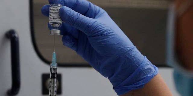 A vial of the Phase 3 Novavax coronavirus vaccine is seen ready for use in the trial at St. George's University hospital in London, Oct. 7, 2020. The Novavax COVID-19 vaccine that could soon win federal approval may offer a boost for the U.S. military: an opportunity to get shots into some of the thousands of service members who have refused the vaccine for religious reasons. (AP Photo/Alastair Grant, File)