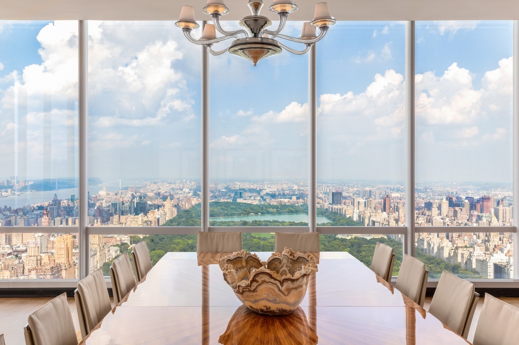 The One57 rental unit's dining area looks to the same panoramic view through massive exposures.