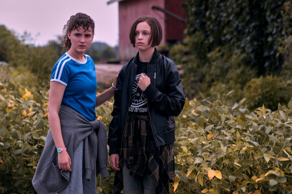 KJ Brandman (Fina Strazza), left, and Mac Coyle (Sofia Rosinsky), right, in "Paper Girls" stand in a field. 