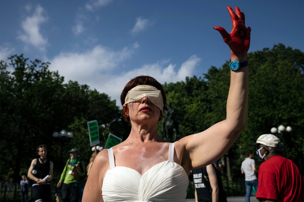 An abortion-rights activist wears a blindfold with her left hand in red paint during a protest in Union Square on June 24, 2022.