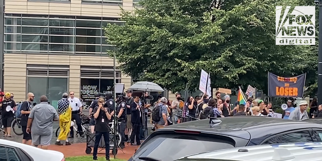 Liberal and conservative protesters shouted at each other across the street in front of the venue of former President Donald Trump's speech to the America First Agenda Summit. 