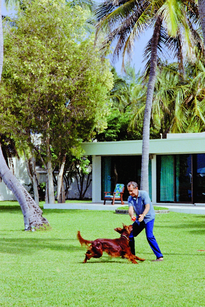 Richard Nixon displayed an uncharacteristically casual moment playing with Irish Setter King Timahoe in Key Biscayne, Fla., in 1971.