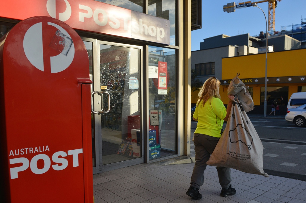 A worker carries a sack of letters