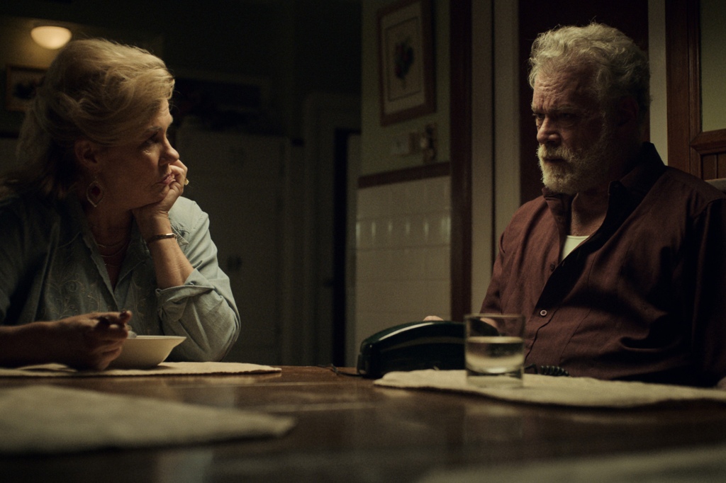 Robyn Malcolm and Ray Liotta as TK and James Keene in "Black Bird." They're sitting at a kitchen table; she's got her hand on her face and he's looking angry.