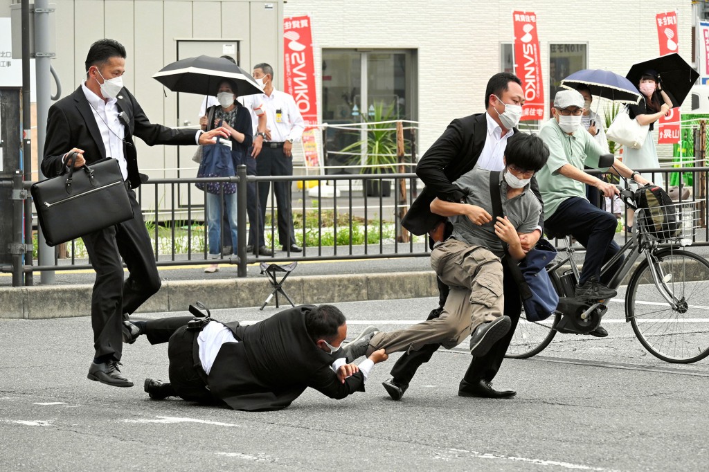 Security tackles to arrest a suspect who is believed to have shot former Prime Minister Shinzo Abe.