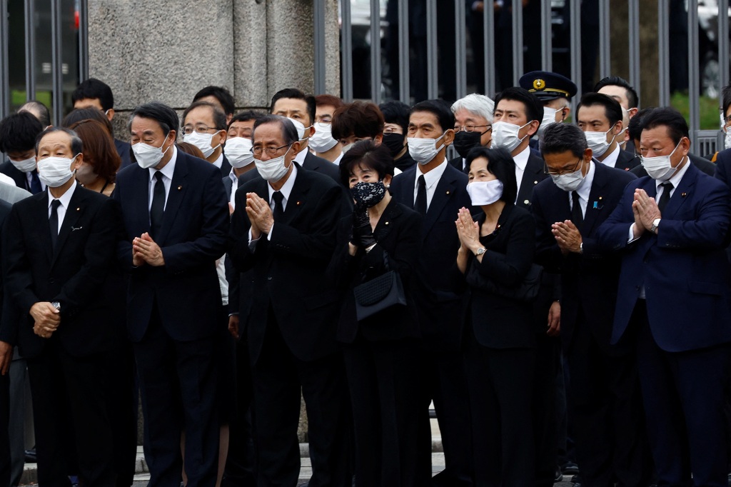 Lawmakers pray towards the vehicle carrying the body of the late former Japanese Prime Minister Shinzo Abe in front of Japan's National Diet Building after the funeral in Tokyo, Japan on July 12, 2022. 