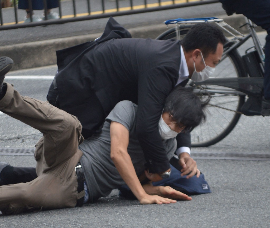 A man (bottom) suspected of shooting former Japanese prime minister Shinzo Abe is tackled to the ground by police at Yamato Saidaiji Station in the city of Nara on July 8, 2022. - Shinzo Abe was shot at a campaign event on July 8, a government spokesman said, as local media reported the nation's longest-serving premier was showing no vital signs. (Photo by Yomiuri Shimbun / AFP) / Japan OUT / NO ARCHIVES (Photo by STR/Yomiuri Shimbun/AFP via Getty Images)