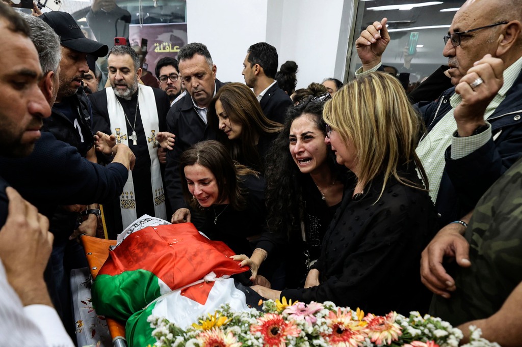 Colleagues and friends react as Abu Akleh's body is brought to the Al Jazeera office in the West Bank.