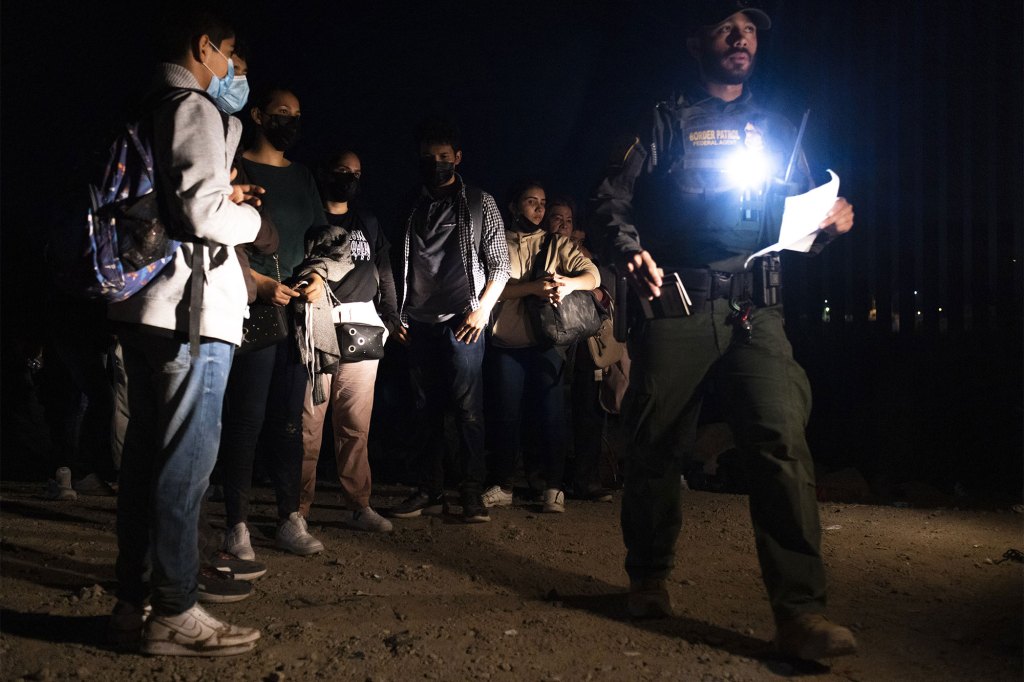 Migrants seeking asylum wait to be processed by U.S. Border Patrol agents after crossing the Mexico and U.S. border in Yuma, Arizona.