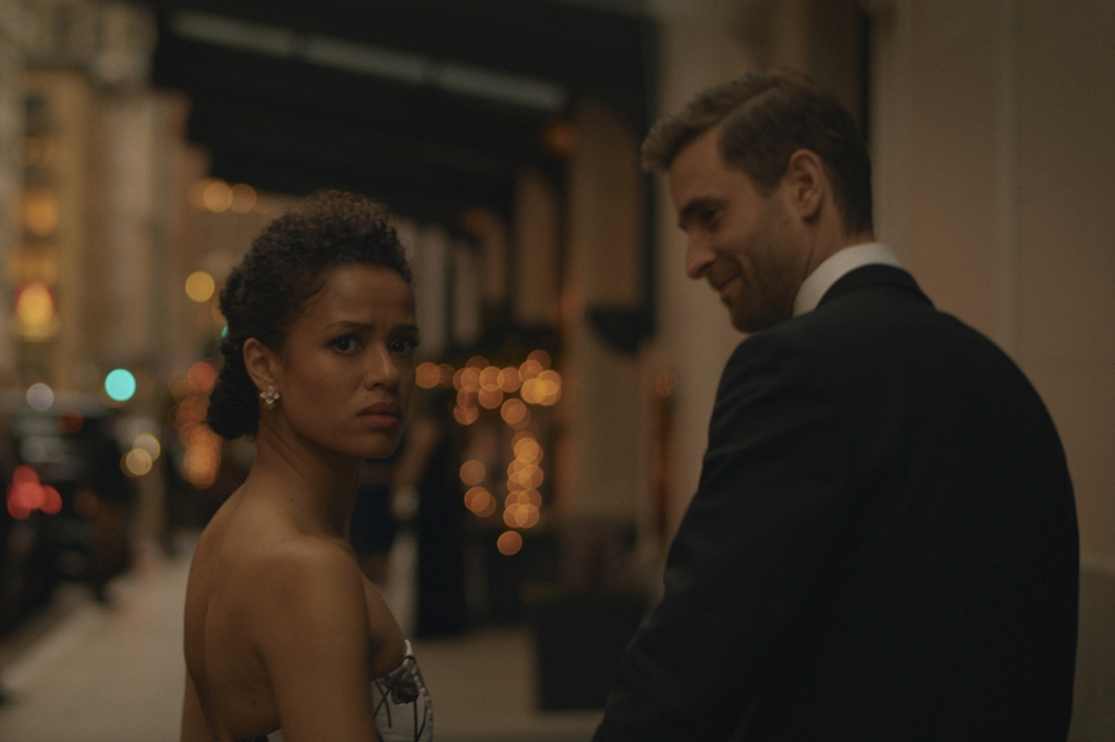 Gugu Mbatha-Raw and Oliver Jackson-Cohen in “Surface" on a sidewalk in fancy clothes. 