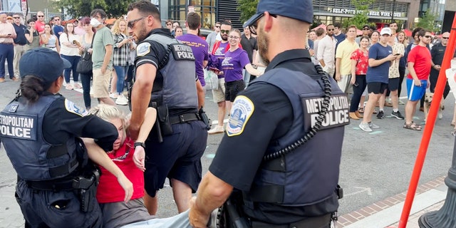 A climate protester is carried away by Metropolitan Police officers before being arrested.