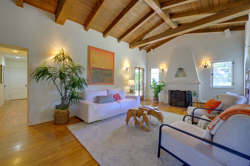 The living room has a dramatic vaulted and beamed ceiling.